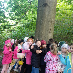 Pierwszaki w lesie na lekcji przyrody